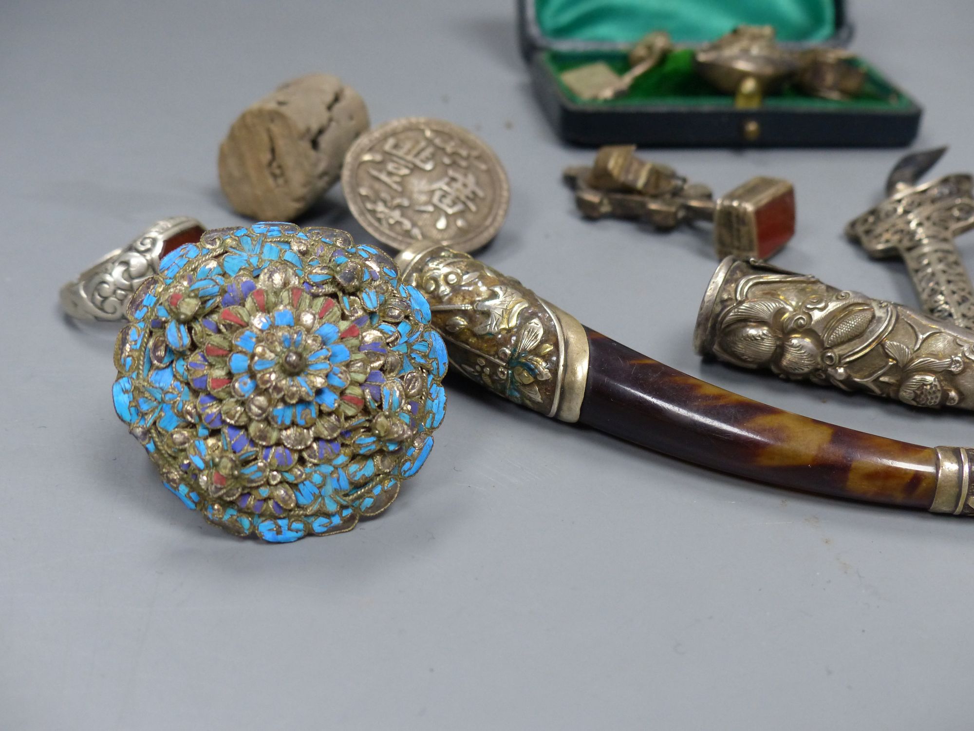 Assorted Chinese white metal items including a menu holder, nail guard, charms, brooches etc.